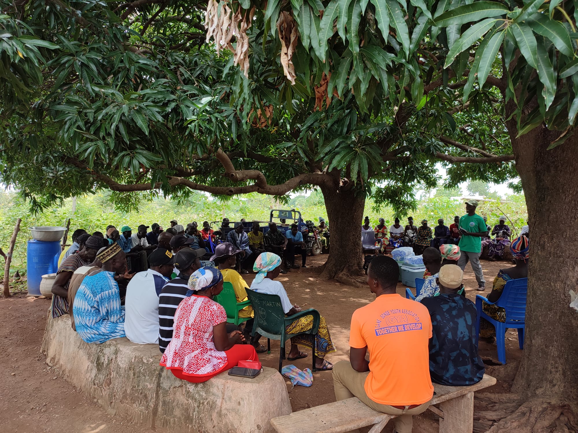 Een groep mensen in Ghana krijgen uitleg over duurzame landbouw.