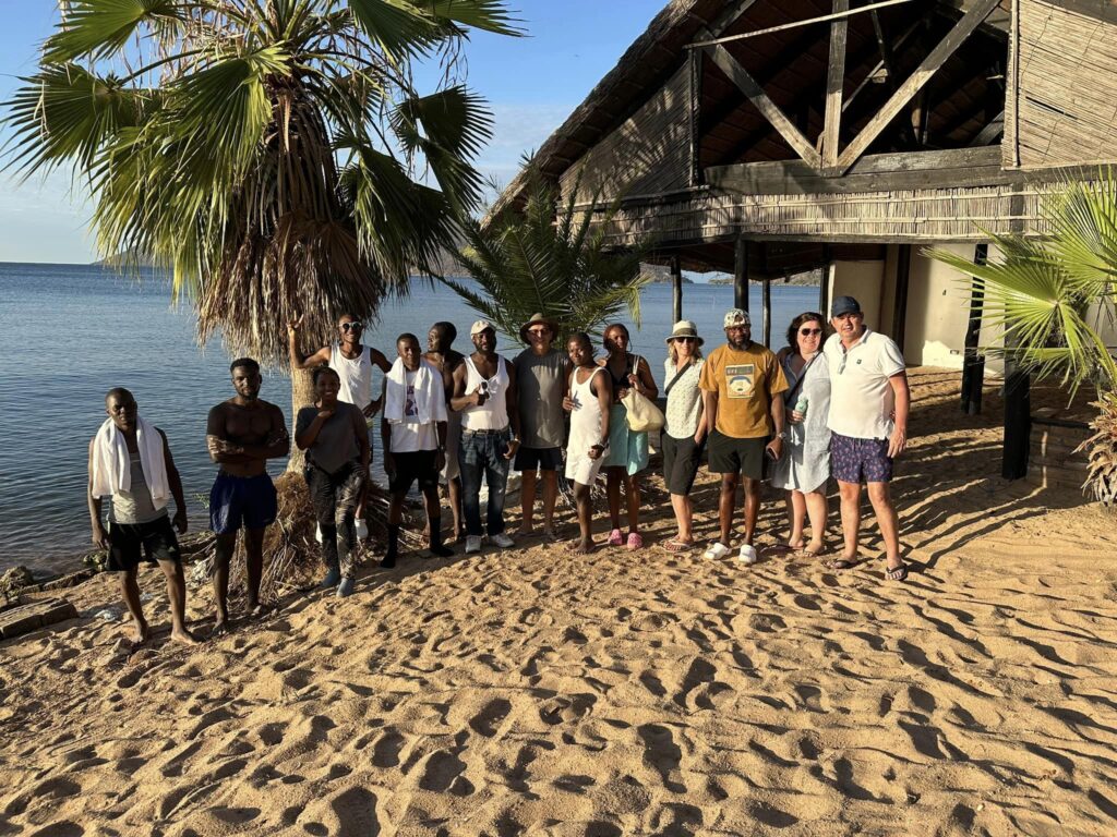 Team Mitongwe poseert op strand voor groespfoto