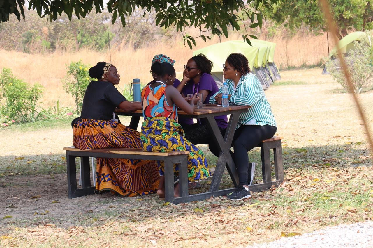 Zambiaanse vrouwen vergaderen aan picknick tafel